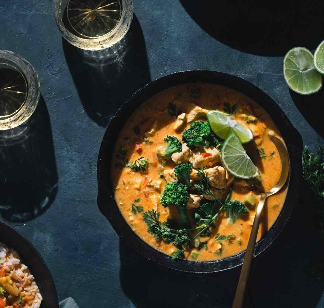 Curry sri-lankais crémeux servi dans une poêle, avec brocolis et citron vert